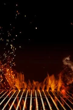 Empty steel barbecue BBQ grill grate with flaming fire, sparks and smoke on Stock Photos