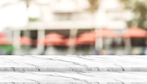 Empty step white marble top food stand with blur umbrella at resort hotel bac Stock Photos