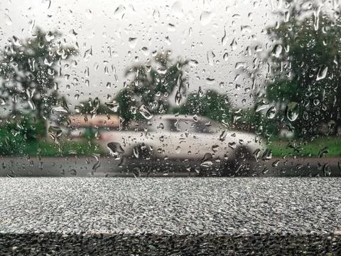 Empty stone shelf with rain falling on blurred street glass with cars for d.. 写真素材