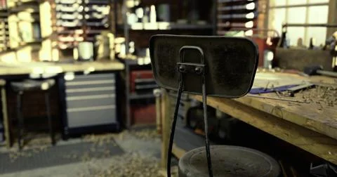 Empty stool in a woodworking shop surrounded by tools and clutter Stock Illustration