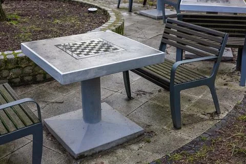 Empty street chess table and benches in a city park. Stock Photos