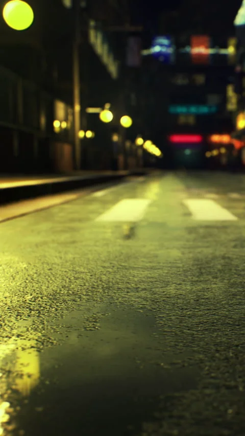 Empty street with wet pavement and city lights at night in a quiet setting Stock Footage 334191686