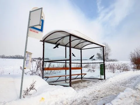 Empty suburban bus stop covered with snow in winter. Slipery pavement with sa Stock Photos
