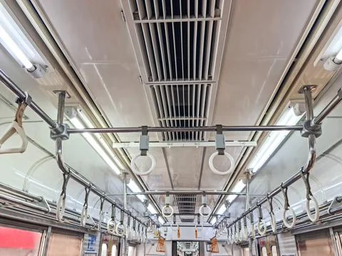 Empty subway train interior with hanging hand straps for passengers 스톡 사진
