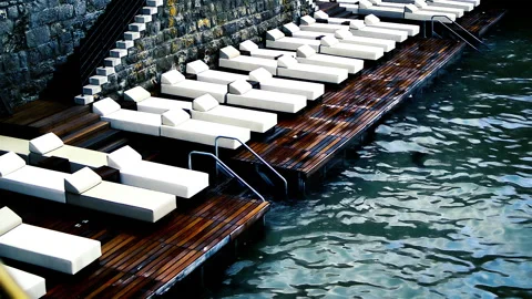Empty sun beds standing on wet wooden made dock. Stock Footage 152956569