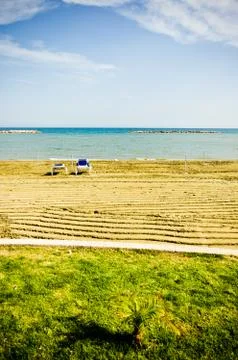Empty sunbeds on beach during low season Stock Photos