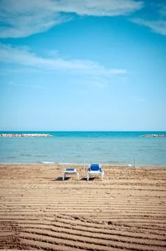 Empty sunbeds on beach during low season Stock Photos