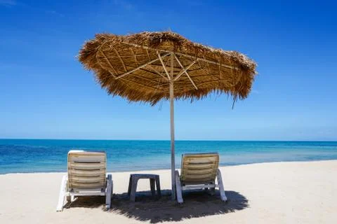 Empty sunbeds on deserted beach Stock Photos