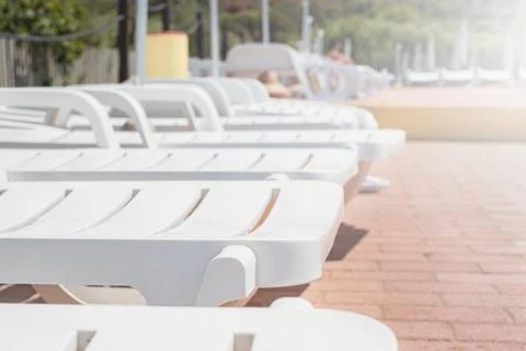 Empty sunbeds by the resort pool Stock Photos