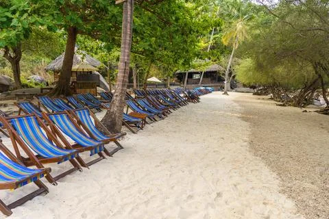 Empty sunbeds in row on seclude tropical sandy beach on Koh Tao Stock Photos