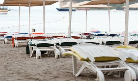 Empty sunbeds on a sandy beach Stock Photos