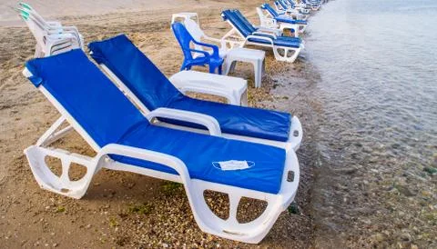 Empty sunbeds on the seashore Stock Photos