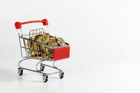 An empty supermarket cart with red inserts on a white background with coins. Stock Photos