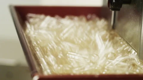 Empty Supplement Capsules being fed into a Production Machine Stock Footage 50031612