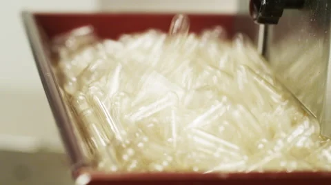 Empty Supplement Capsules being fed into a Production Machine Stock Footage 50033578