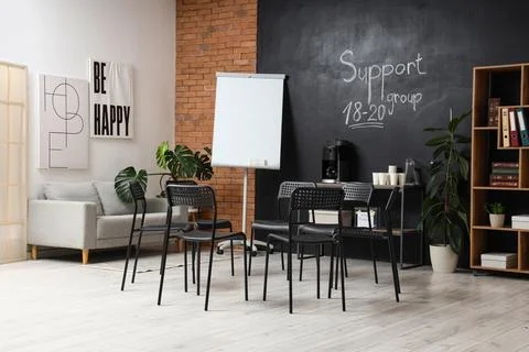 Empty support group meeting room with chairs and flip chart Stock Photos