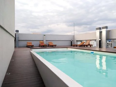 Empty swimming pool with nice turquoise water. Solarium deck in a terrace wit Stock Photos