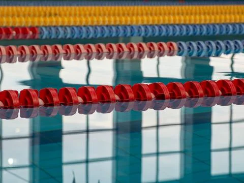 Empty swimming pool with red blue and yellow lane dividers Stock Photos