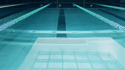 Empty swimming pool with small ripples and daylight reflection from skylight Stock Footage 107734876