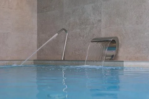 Empty swimming pool with waterfall jet in action Фото