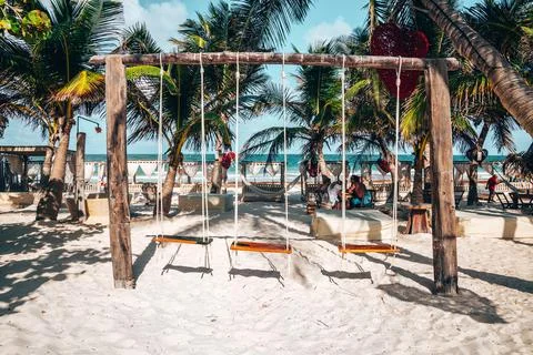 Empty swing and heart shape artwork hanging on tree at beach resort with Stock Photos