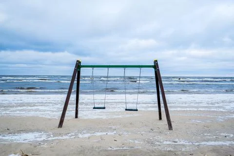 Empty swing on the beach by the sea in winter. Foto stock