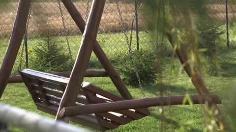 Empty swing bench in garden Stock Footage 128800738