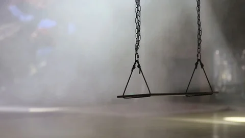 Empty swing on chains moves in a dark room Stock Footage 127636975