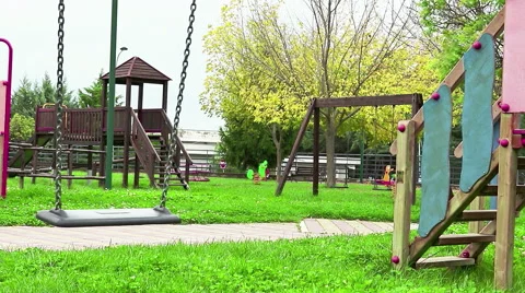 Empty swing with chains swaying at playground for child, moved from wind, on Video stock 56710242