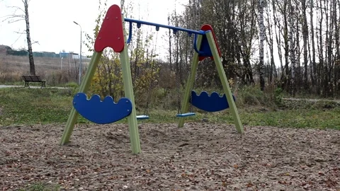 Empty swing during a pandemic lockdown in autumn park Stock Footage 142513647