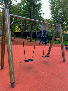 Empty swing on an empty children playground Stock Photos