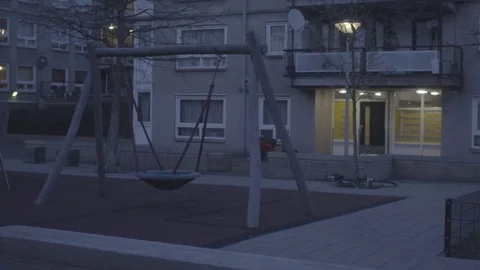 Empty swing in front of a residential building Stock Footage 73703479