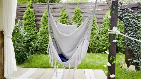 An empty swing on the garden porch, a hammock, a Brazilian rocking chair on.. Stock Footage 314371725