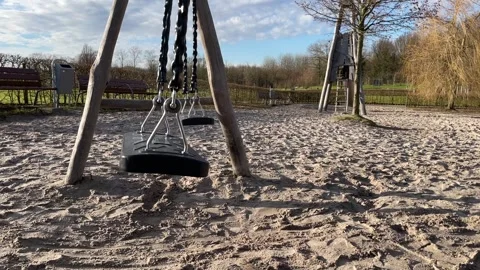Empty Swing Gently Swinging in Children Playground Close Up Stock Footage 332801744
