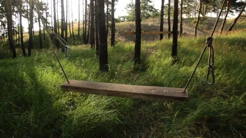 Empty swing move in playground at sunrise Stock Footage 70677700