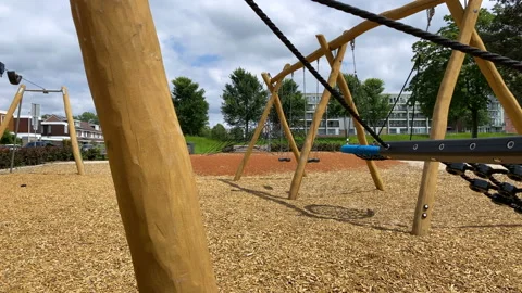 Empty  swing moves at the closed playground 스톡 동영상 136031582