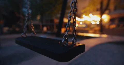 Empty swing moving at night Stock Footage 188467806