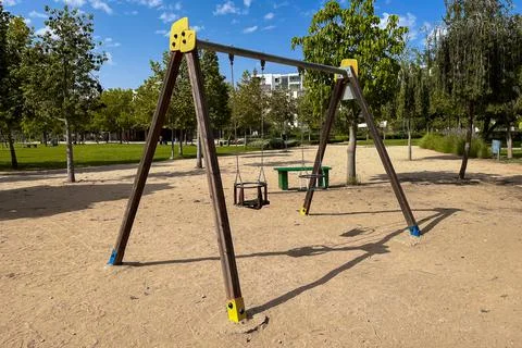 An empty swing in the park with trees in the background Fotos Stock