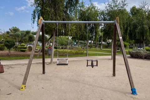 An empty swing in the park with trees in the background Fotos Stock