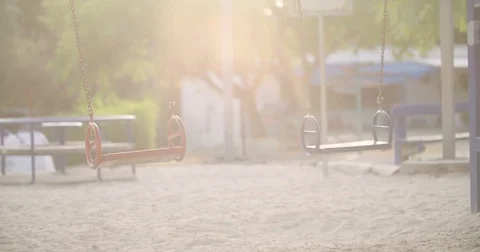 Empty swing in a playground at dusk Stock Footage 77961999