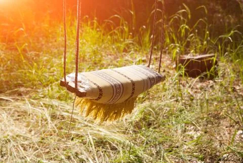 Empty Swing on ropes at Sunset forest Stock Photos