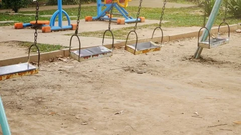 Empty swing seat swaying in park playground Video stock 77606124