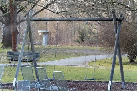 Empty swing set in quiet park area Stock Photos