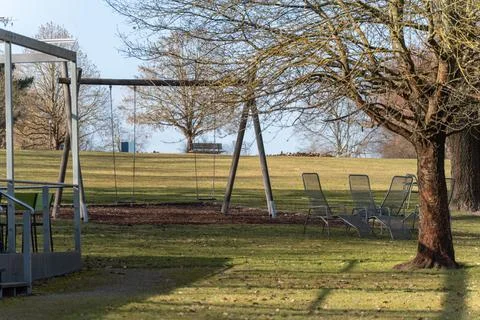 Empty swing set stands in a quiet park Stock Photos
