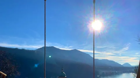 Empty Swing with Sunlight and Mountain View with a Church Tower Stockbeeldmateriaal 191935921