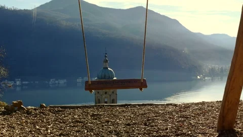 Empty Swing with Sunlight and Mountain View with a Church Tower Stock Footage 194012035