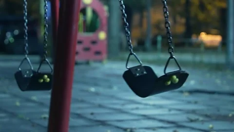 Empty Swing Swaying on Chains at Dusk | Autumn Evening at Deserted Playground Stock Footage 319358031
