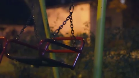 Empty Swing Swaying on Chains at Night | Playground Equipment in Motion Stock Footage 318488986