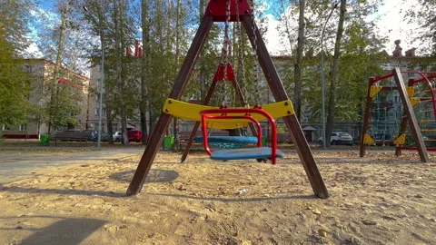 Empty swing swaying in playground during autumn Stock Footage 314032207