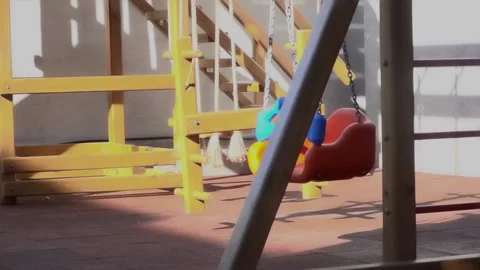 An empty swing, swinging alone in a playground without children. Stock Footage 133774830